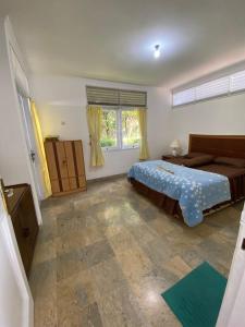 een slaapkamer met een bed en een groot raam bij Villa Nesa in Cipanas