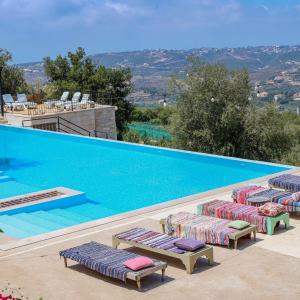 a swimming pool with chaise lounge chairs next to it at Abdelli Terraces in Batroun in Batroûn