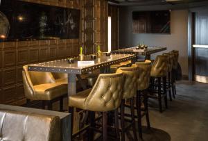 a bar with a row of tables and chairs at Hotel Gotham in Manchester