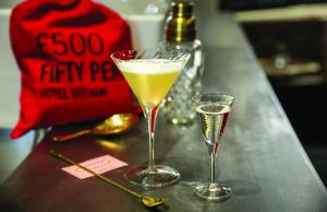 two champagne glasses sitting on a counter with a drink at Hotel Gotham in Manchester