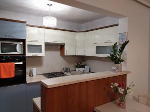 a kitchen with white cabinets and a counter top at Apartament Dymińska in Warsaw