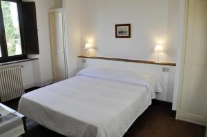 1 dormitorio con 2 camas con sábanas blancas en Agriturismo La Colombera in Toscana, en Roccalbegna