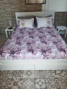 1 cama con edredón y almohadas de color púrpura y blanco en Angel Room 2, en Nea Plagia