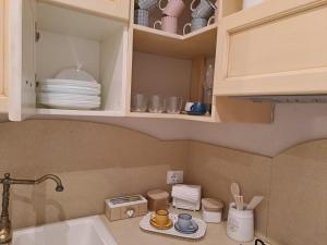 a kitchen with a sink and a cupboard with dishes at Dimora Vico Storella in Lecce