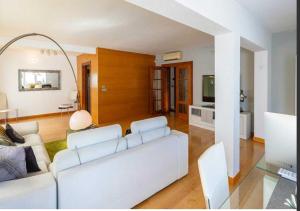 un salon avec un canapé blanc et une télévision dans l'établissement la casita de la playa 13, à El Campello