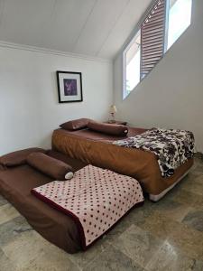 two beds sitting in a room with at Villa Nesa Puncak Cipanas in Cipanas