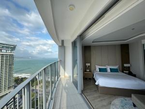 a bedroom with a bed and a balcony with the ocean at Panorama Nha Trang Sky Beach in Nha Trang