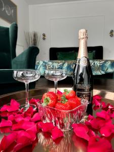 - une table avec deux verres à vin, des fraises et des roses rouges dans l'établissement Coeur Nature, à Arsimont