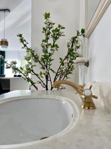 La salle de bains est pourvue d'un lavabo et d'un vase de fleurs. dans l'établissement Coeur Nature, à Arsimont