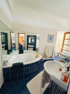 een grote badkamer met een bad en 2 wastafels bij Cannes appartement à 300 m des plages in Cannes