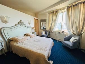 een slaapkamer met een bed, een stoel en een raam bij Cannes appartement à 300 m des plages in Cannes