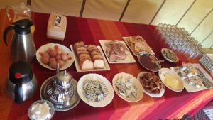 una tavola ricoperta di piatti di cibo su un tavolo di camp erg znaigui a Taouz