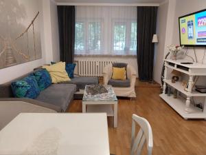 a living room with a couch and a tv at Apartament Dymińska in Warsaw