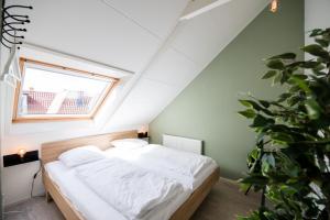 Schlafzimmer mit einem Bett mit weißer Bettwäsche und einem Fenster in der Unterkunft Studio 18 in Nes