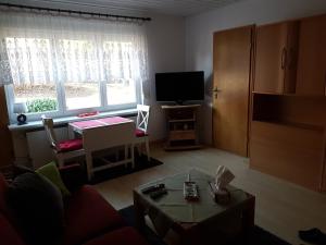 uma sala de estar com uma televisão e uma mesa em Ferienwohnung Witt em Neustrelitz