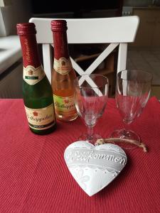 uma mesa com duas garrafas de vinho e dois copos em Ferienwohnung Witt em Neustrelitz