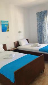 um quarto com duas camas com lençóis azuis em Red Sun Apartments em Amoudi