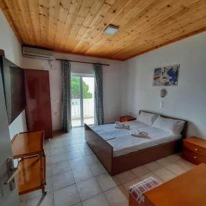 um quarto com uma cama e um tecto de madeira em Red Sun Apartments em Amoudi
