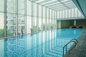 einen Pool in einem Gebäude mit Glasfenstern in der Unterkunft Crowne Plaza Jiangmen Binjiang, an IHG Hotel in Jiangmen
