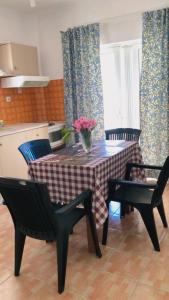 a kitchen with a table with a vase of flowers on it at Red Sun Apartments in Amoudi