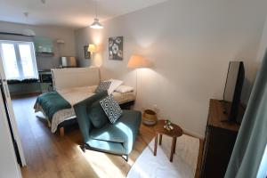 ein Schlafzimmer mit einem Bett und einem blauen Stuhl in der Unterkunft Hérisson in Arbent