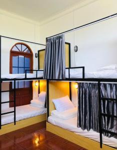 a room with two bunk beds and a mirror at HOSTEL ECO TOURISM CẦN GIỜ in Cần Giờ