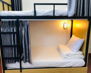 a bunk bed with a white pillow on it at HOSTEL ECO TOURISM CẦN GIỜ in Cần Giờ