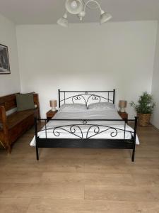 a bedroom with a black bed and a couch at Pelini - 2 in Szentendre