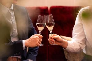 two people holding champagne glasses in their hands at Hotel Krone Langenegg in Langenegg