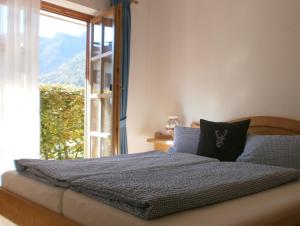 a bedroom with a bed with a large window at Alpenresidenz Chiemgau in Schleching