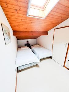 Cette petite chambre dispose de 2 lits et d'une lucarne. dans l'établissement La Tiloé des dunes ~ T3 centre de la Palmyre, aux Mathes