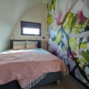 een slaapkamer met een bed met een muurschildering van bloemen bij GreenFloat Boskoop #2 in Boskoop