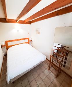 małą sypialnię z łóżkiem i lustrem w obiekcie La Tiloé des dunes ~ T3 centre de la Palmyre w mieście Les Mathes