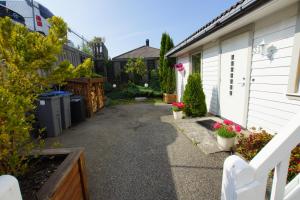 uma entrada que leva a uma casa com flores e plantas em Cozy Room with Garden on Askøy Island, Close to Bergen em Askøy