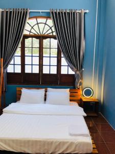 1 dormitorio con 2 camas y ventana en HOSTEL ECO TOURISM CẦN GIỜ en Can Gio