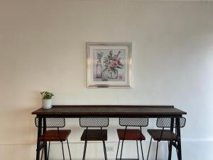 羅勇的住宿－Gao Check in Phala Beach Front，一张桌子、四把椅子和一张墙上的照片
