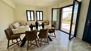 a dining room with a table and chairs and a couch at Moutzouri Villes in Thános