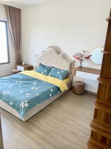a bedroom with a bed with blue sheets and blue pillows at Vinhomes Smartcity- Căn hộ dich vụ - 3 Bedroom in Hanoi +9 photos