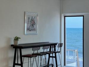 羅勇的住宿－Gao Check in Phala Beach Front，海洋间里的桌椅