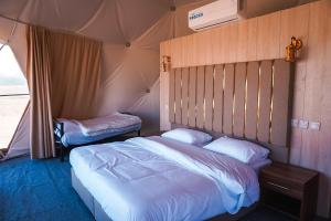 a bedroom with two beds in a tent at Mirage Camp Wadi Rum in Wadi Rum