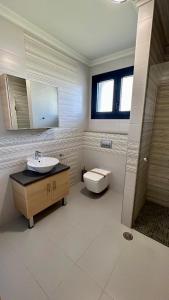 a bathroom with a sink and a toilet at Moutzouri Villes in Thános