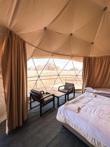 sypialnia z łóżkiem i dużym namiotem w obiekcie Mirage Camp Wadi Rum w mieście Wadi Rum