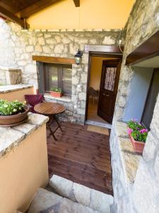 een patio met een houten vloer en een houten tafel bij Dryas Guesthouse in Polydrossos