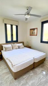 a large bed in a bedroom with a ceiling fan at Moutzouri Villes in Thános