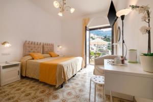 Schlafzimmer mit einem Bett, einem Schreibtisch und einem Fenster in der Unterkunft Florida Residence in Positano