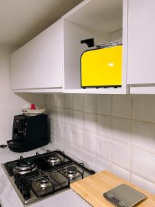 eine Küche mit einem Herd und einer gelben Mikrowelle in der Unterkunft La Casetta di Giggè in Palermo