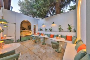 an outdoor patio with tables and chairs and a couch at Old Town Hotel Kalkan in Kalkan