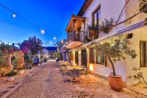 a cobblestone street with tables and chairs next to a building at Old Town Hotel Kalkan in Kalkan