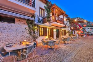 a patio with tables and chairs in front of a building at Old Town Hotel Kalkan in Kalkan