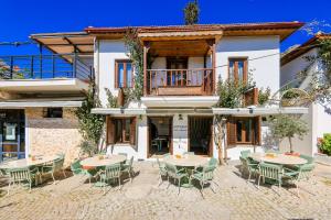 an outdoor patio with tables and chairs in front of a building at Old Town Hotel Kalkan in Kalkan